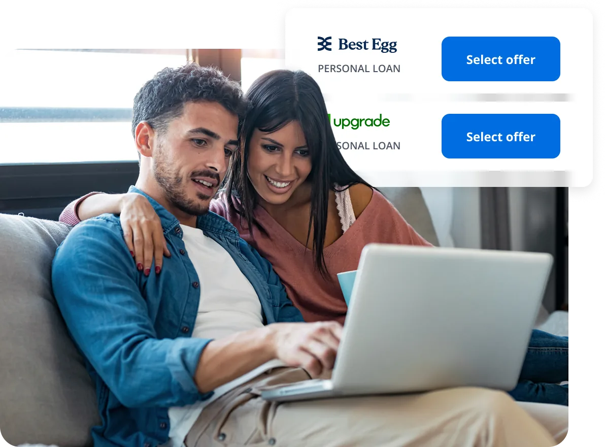 Couple on the couch reviewing personal loan offers on a laptop